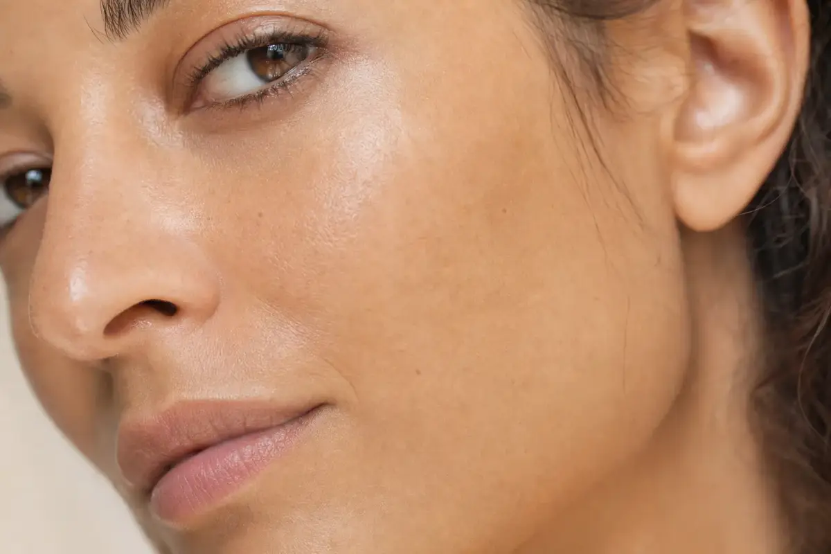 Macro close-up of the smooth cheek of a woman in her thirties with olive skin