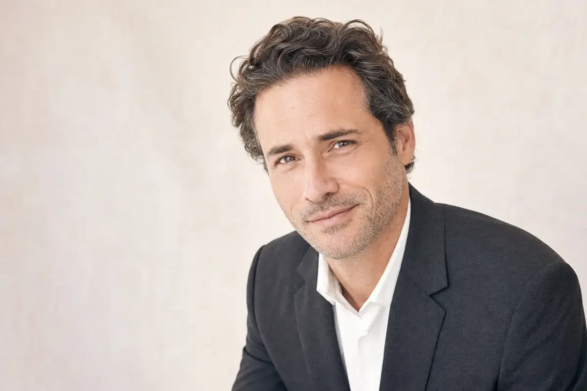 Portrait of a well groomed man in his early forties in a tailored charcoal jacket