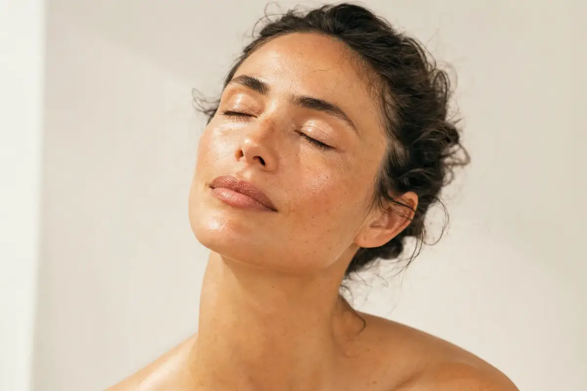 Woman in her thirties with sun kissed glowing skin and a few freckles